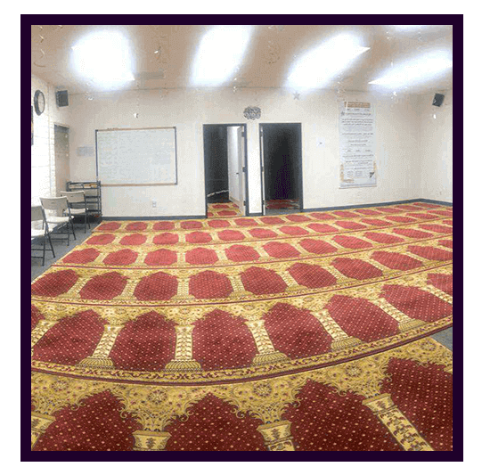 The prayer hall at MVPA Musalla, with rows of prayer rugs